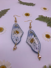 Load image into Gallery viewer, Daisy wing earrings with blue background
