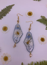 Load image into Gallery viewer, Daisy wing earrings with blue background
